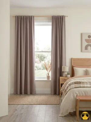 "Gri mobilyalar ve ekru keten tüllerle dekore edilmiş modern bir yatak odasında, pencerelere zarafet katan Polvere pudra fon perde."