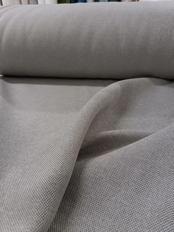 "Modern minimalist dekorasyon anlayışına uygun, gün ışığını yumuşakça filtreleyerek odayı ferah gösteren kaliteli gri keten perde görseli."