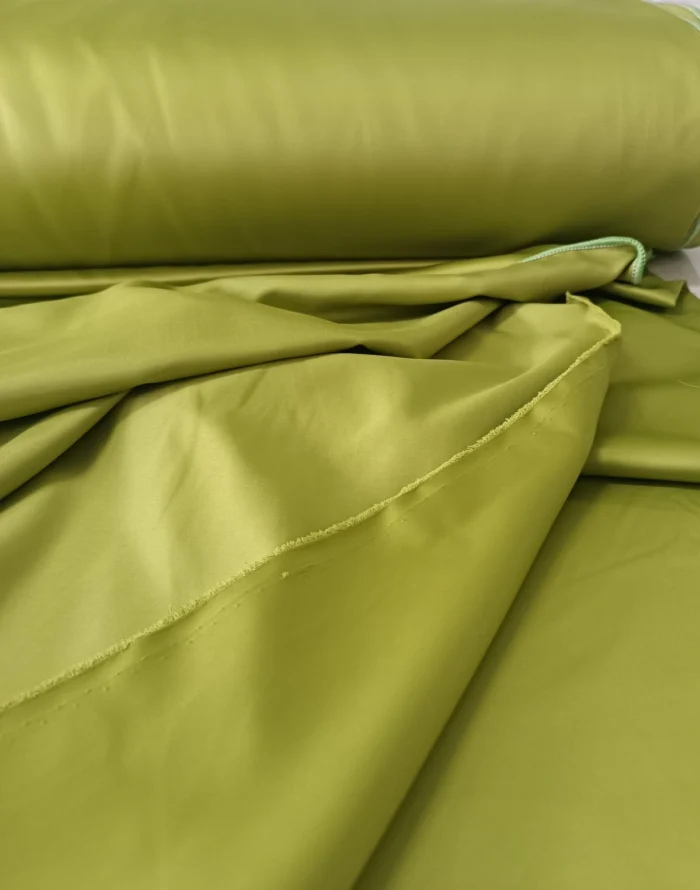 "Kırışmaya dayanıklı yapısı ve ütü gerektirmeyen kaliteli saten dokusuyla modern evler için ideal premium fıstık yeşili fon perde detayı."