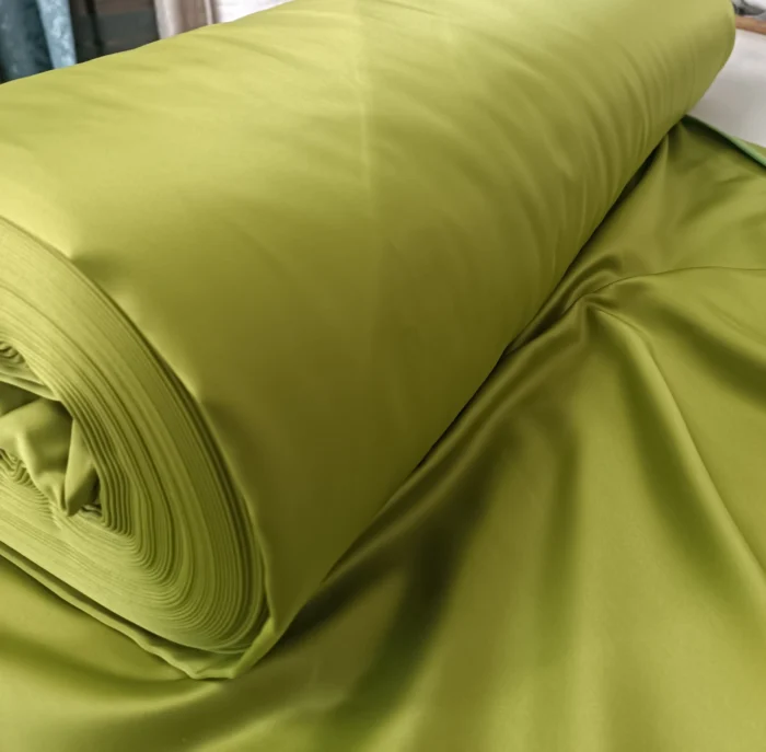 "Geniş salon pencerelerinde tavandan yere kadar uzanan, odayı daha ferah ve canlı gösteren sık pileli yeşil saten fon perde."