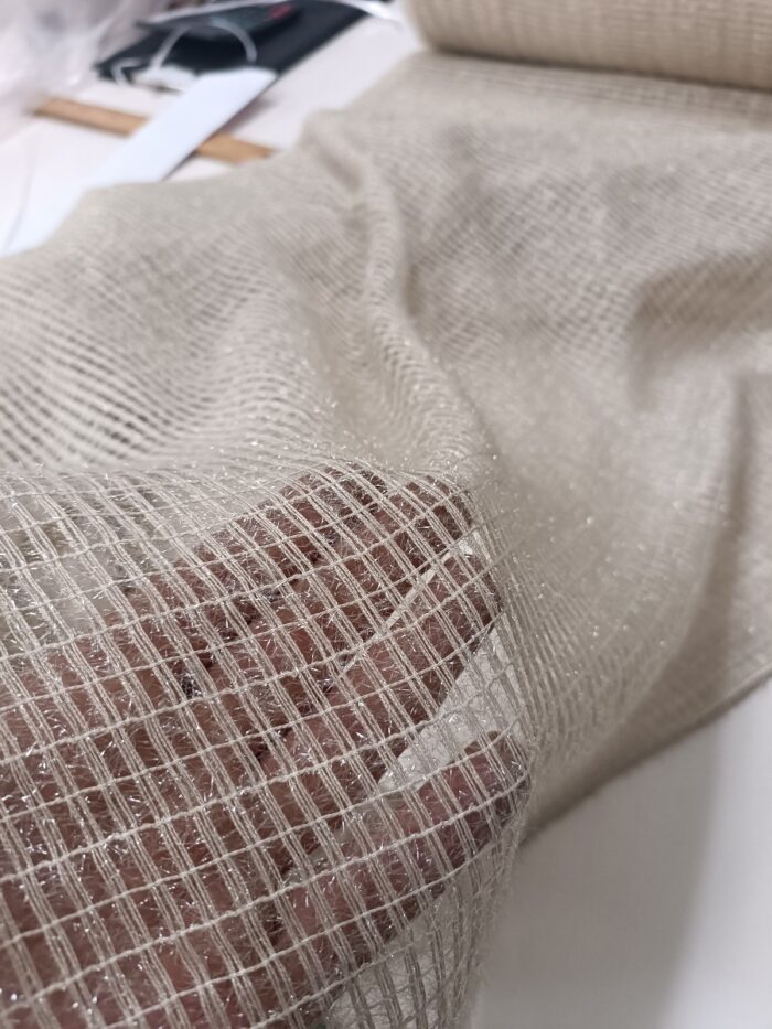 "Kırışmaya dayanıklı ve ütü gerektirmeyen gözenekli Argento tül perde ipliklerinin esnek yapısını gösteren profesyonel kumaş fotoğrafı."