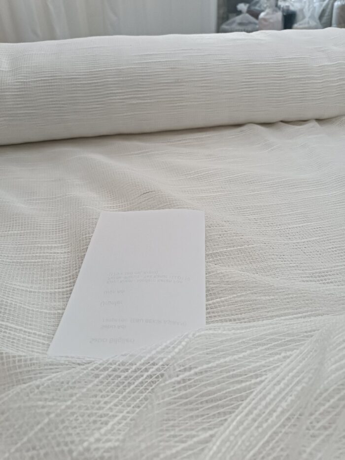 "Kırışmaya dayanıklı ve ütü gerektirmeyen gözenekli Simena tül perde ipliklerinin esnek yapısını gösteren profesyonel kumaş fotoğrafı."