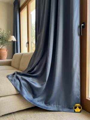 "Ekonomik koyu gri karartma blackout fon perdenin pilesiz düz dikim panel yapısının modern bir salonda yarattığı rafine, ferah ve minimalist atmosfer."