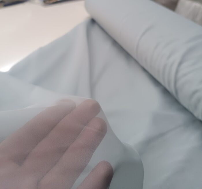 "Geniş salon pencerelerinde tavandan yere kadar uzanan, dökümlü ve nizamlı duran sık pileli buz mavi rüstik düz tül tasarımı."