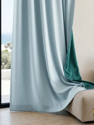 "Monsaraz buz mavisi karartma blackout fon perdenin çift taraflı dokusu ve turkuaz arka yüzeyinin modern bir salonda yarattığı rafine ve minimalist atmosfer."