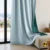 "Monsaraz buz mavisi karartma blackout fon perdenin çift taraflı dokusu ve turkuaz arka yüzeyinin modern bir salonda yarattığı rafine ve minimalist atmosfer."