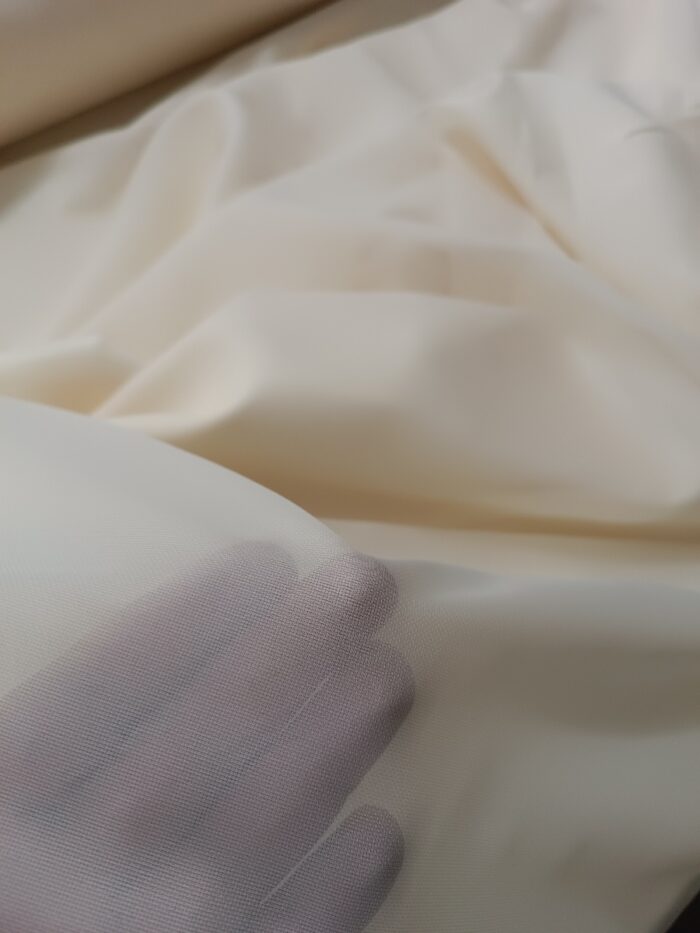 "Mat siyah metal rüstik borulara asılmış, modern panel duruşu sergileyen kaliteli Soria krem düz dokulu tül perde modeli."