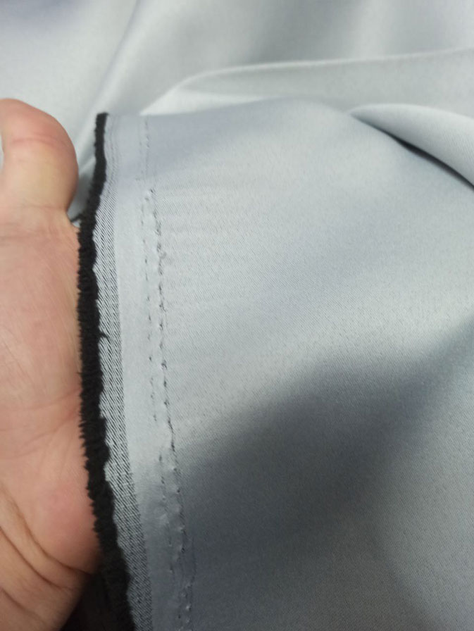 "Geniş yatak odası pencerelerinde tavandan yere kadar uzanan, dökümlü ve nizamlı duran sık pileli gri karartma fon tasarımı."
