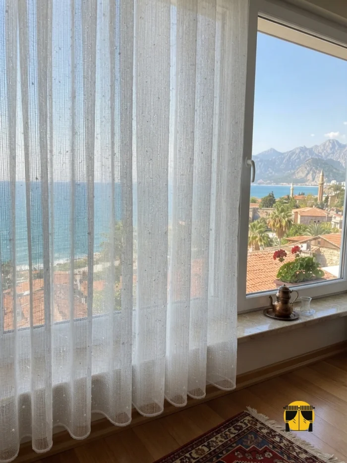 "Dışarıdan gelen keskin gün ışığını pırıltılı yapısıyla süzerek oturma odasında huzurlu, soft ve krem tonlarında bir aydınlık yaratan kaliteli desenli tül."